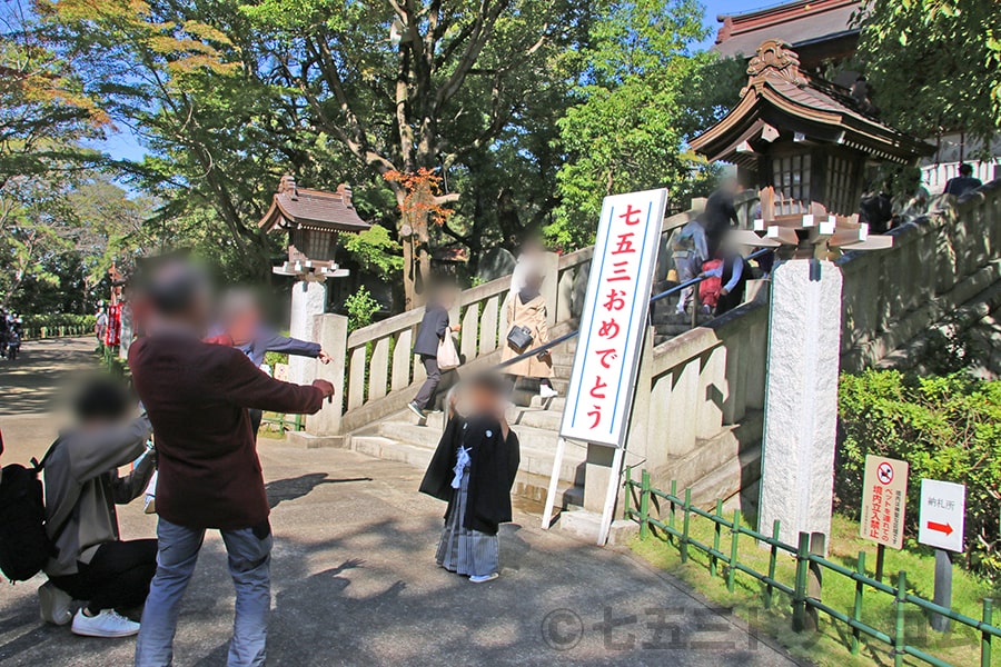 稲毛浅間神社 神門前の七五三おめでとう看板前で記念撮影する七五三ご家族の様子