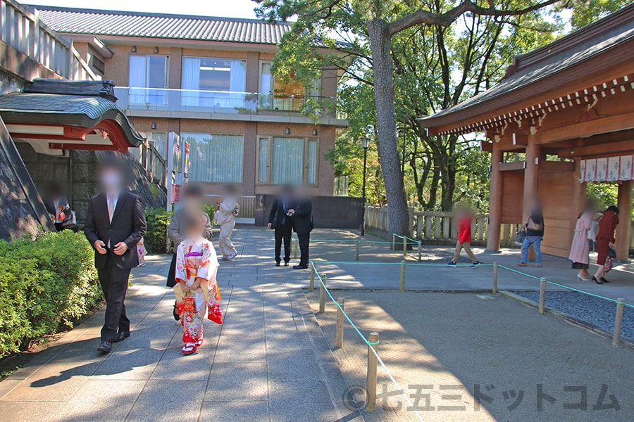 稲毛浅間神社 神門内本殿手前の手水のある場所を進む七五三ご家族の様子