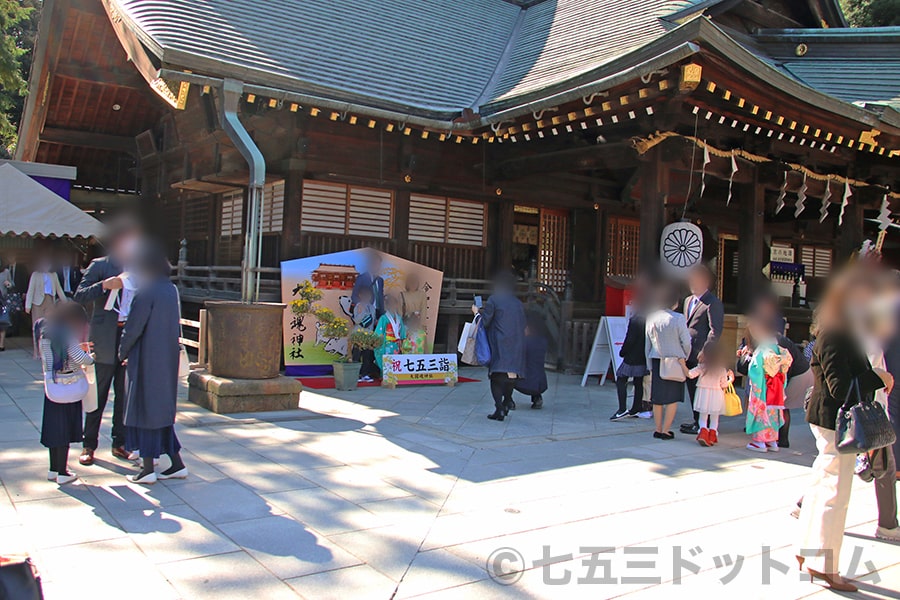 大國魂神社 本殿までの大絵馬で記念撮影する七五三ご家族と待ち行列の様子（その1）